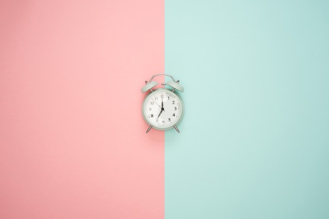 Image of an alarm clock against a pink and blue background